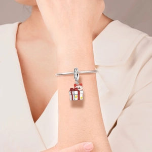 Detail of silver cat charm with red enamel on snake chain worn by a female model