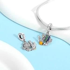 Detailaufnahme von Fisch-Charm mit bunten Zirkoniasteinen und gelbem Seestern