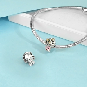 Macro view of S925 silver bouquet charm with yellow stones and pink enamel bow detail