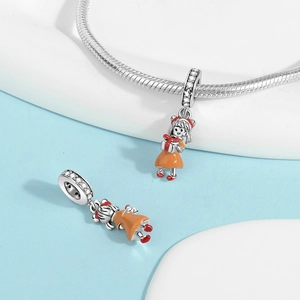 Macro detail of silver girl charms with orange enamel dress and gift box for bracelets