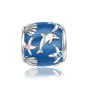 Macro detail of blue enamel charm with silver dolphin starfish and seashell patterns