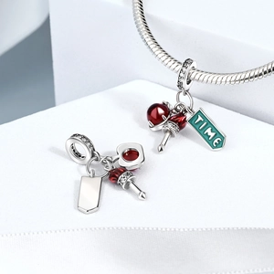 Detail of silver snake chain bracelet with red beads and green TIME enamel charm
