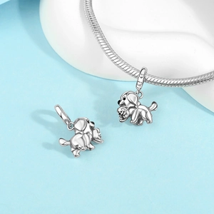 Detail of silver puppy pendant with heart-embossed bail on polished snake chain