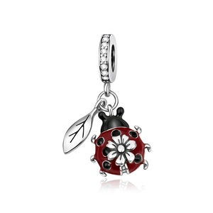 Silver ladybug charm pendant with red enamel and floral detail on white background