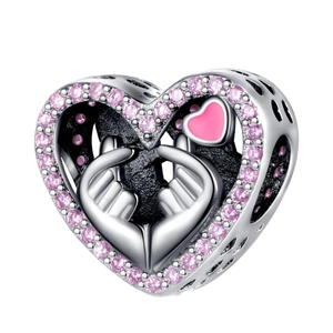 Detail of silver heart charm with pink zircon stones and hollowed hand heart gesture