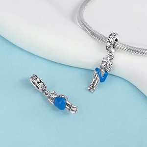 Detailed view of Little Prince charm with blue enamel heart on a silver bracelet