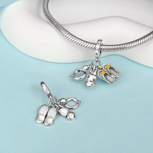 Macro detail of S925 silver summer beach charms featuring swimsuit and flip-flops