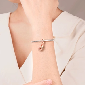 Close-up of rose gold high heel charm with pink crystals on a silver snake chain bracelet