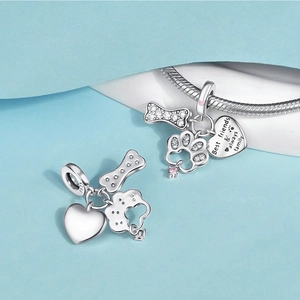 Detail of S925 silver charm with paw, bone, and heart engraving on a snake chain
