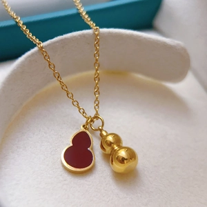 Elegante collana a doppia zucca in oro lucido con ciondolo in smalto rosso su vassoio bianco