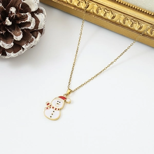 Detail shot of a snowman pendant with white enamel and a red hat on a gold chain