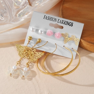 Golden butterfly and pearl earring set with long tassels and large textured hoops on card