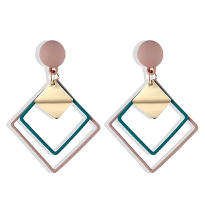 Detail of geometric rhombus earrings with layered blue and pink square resin frames