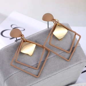 Retro geometric square stud earrings in beige brown and gold finish on a jewelry stand