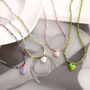 Lot de 4 colliers en perles macaron colorées avec pendentifs cœur au style estival