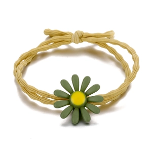 Close-up of yellow elastic hair tie with green daisy flower and bow detail