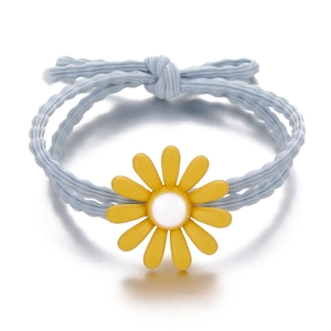 Detail of light blue elastic daisy hair tie with yellow resin flower and woven texture
