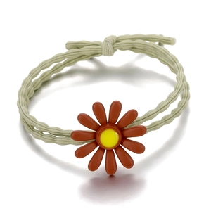 Detail of elastic hair tie with a 3D brick red daisy flower and yellow stamen