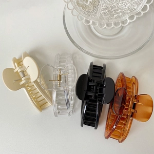 Minimalist large acrylic hair claws in cream, clear, black and amber tones with gold springs