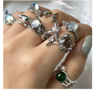 Detalle de anillos de plata con piedra de luna y ágata verde en estilo metal líquido