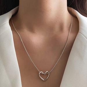 Elegante collana con ciondolo a cuore traforato argento con blazer bianco