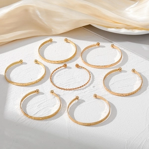 7-piece gold textured open cuff bracelet set featuring twisted rope and star patterns