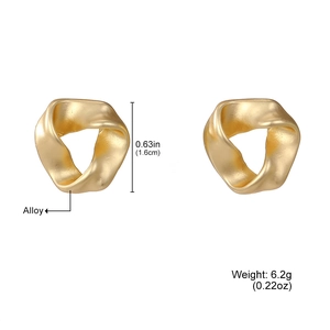 Détail des boucles d'oreilles en alliage d'or mat avec structure géométrique de Mobius