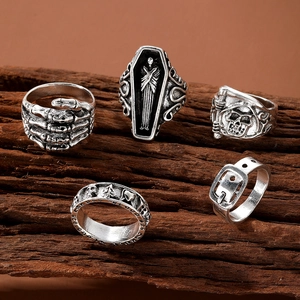 5-piece vintage gothic rings set with skull and coffin designs on dark textured wood