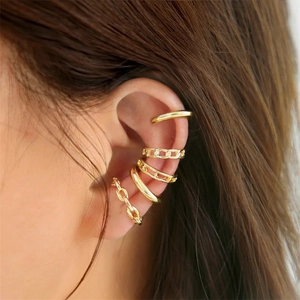Detail von fünf goldenen Earcuffs ohne Piercing mit Ketten- und Geometriedesigns