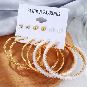 Detailliertes Set aus 6 goldenen Ohrringen mit Perlen und Kristallen auf Display