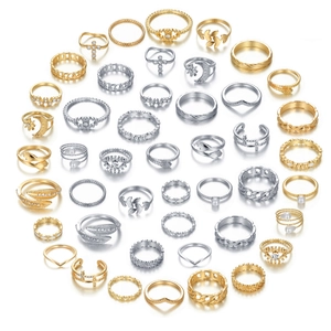 Platliggende set gouden en zilveren ringen met maan-, ster- en kruismotieven op wit