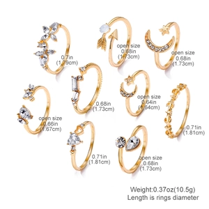 Ensemble de 9 bagues dorées avec lune, papillon et cristaux sur fond blanc épuré