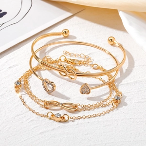 Elegante set de 4 brazaletes dorados con dijes de corazón e infinito sobre seda