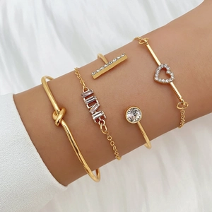 Vierteiliges goldenes Armband-Set mit LOVE-Schriftzug, Herz-Kristallen und Knotendesign