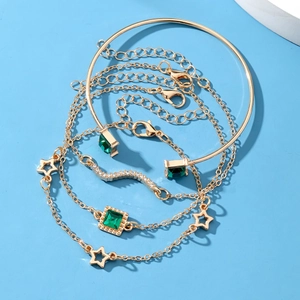 Golden 4-piece bracelet set with emerald square gems and star charms on blue background