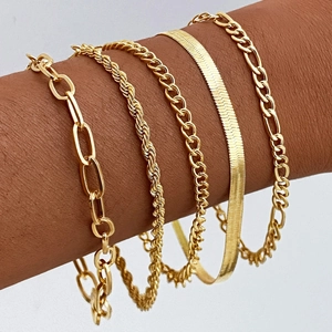 Detailed view of five-piece gold bracelet set featuring paperclip and snake chain links