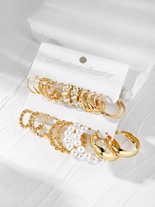 Detailed macro shot of vintage gold C-shaped alloy and pearl earrings set on white stone