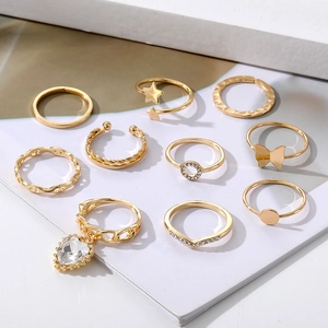 Detailansicht des 10-teiligen goldenen Ring-Sets mit Schmetterling- und Herzanhängern