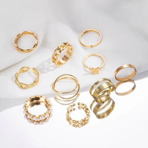 9-teiliges goldenes Ring-Set mit Schmetterling und Perlen auf weißem Samtgrund