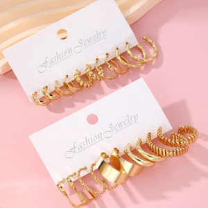 Detailset goldener gedrehter Kettenohrringe und Ringe auf einer Schmuck-Displaykarte