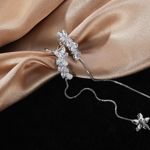 Silver leaf zircon earrings with long tassel chain on luxury silk and velvet background