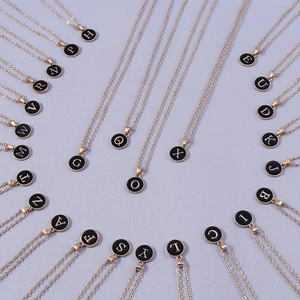 Collar chapado en oro con colgantes redondos de esmalte negro con letras iniciales