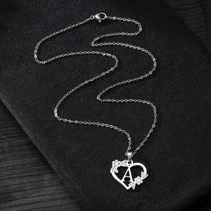 Collana con ciondolo a cuore argento con lettera A e dettagli floreali su sfondo nero