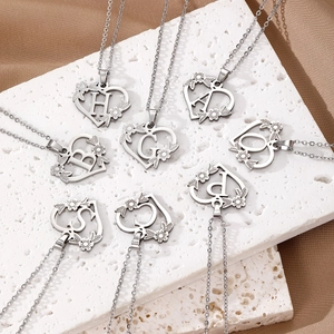 Collane a cuore in argento con iniziali e motivi floreali su base in travertino
