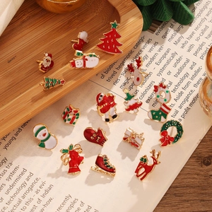 Detailed view of colorful Christmas enamel brooches on book and wooden tray background