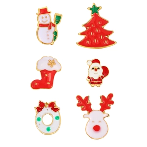 Macro detail of Christmas enamel brooches featuring snowman and reindeer designs