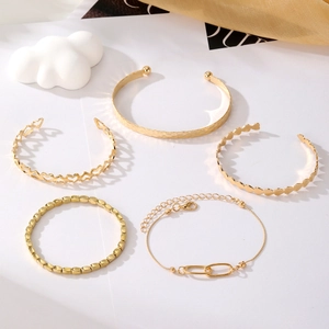 Ensemble de cinq bracelets dorés martelés et ajourés en forme de cœur avec chaînes