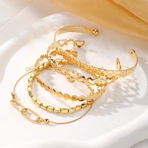 Coffret de quatre bracelets dorés avec manchette martelée et motifs cœur ajourés chic