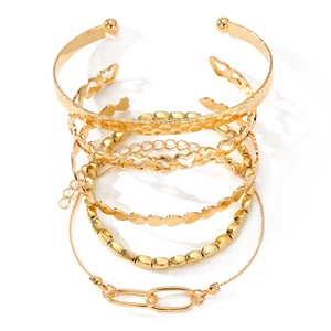 Ensemble de cinq bracelets dorés avec manchette martelée et chaîne à cœur évidé