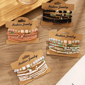 Detailed overhead view of multilayer bohemian beaded bracelets on wood background